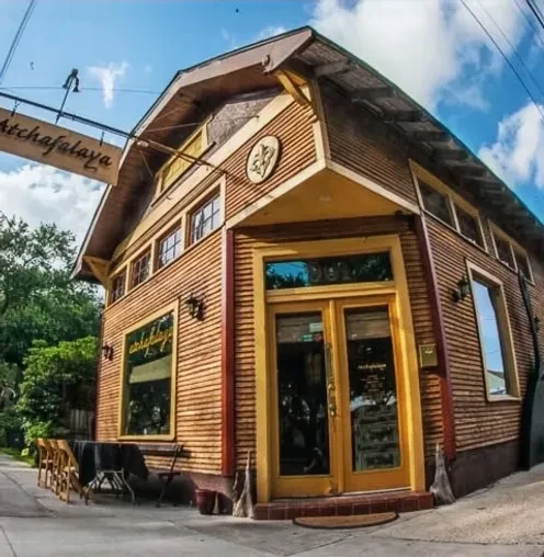 Atchafalaya restaurant's two-story wooden exterior with outdoor seating.
