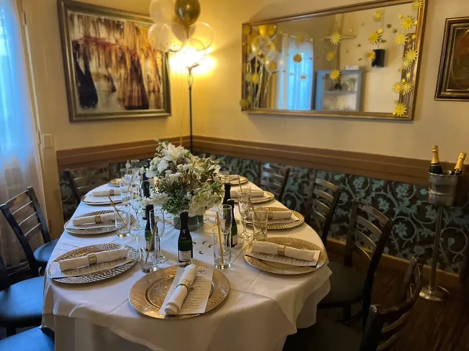 Festively decorated dining table with champagne, floral centerpieces, and place settings.