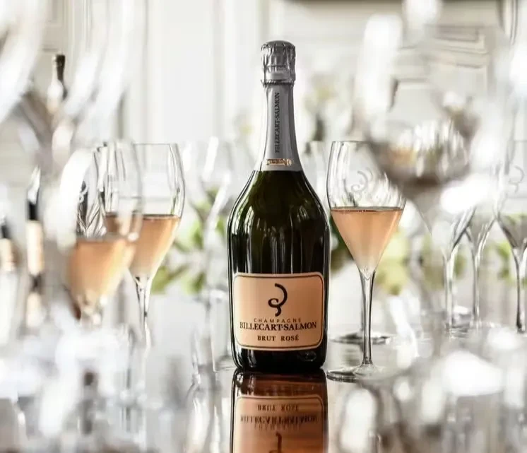 Bottle of Billecart-Salmon Brut Rosé champagne and filled flutes.