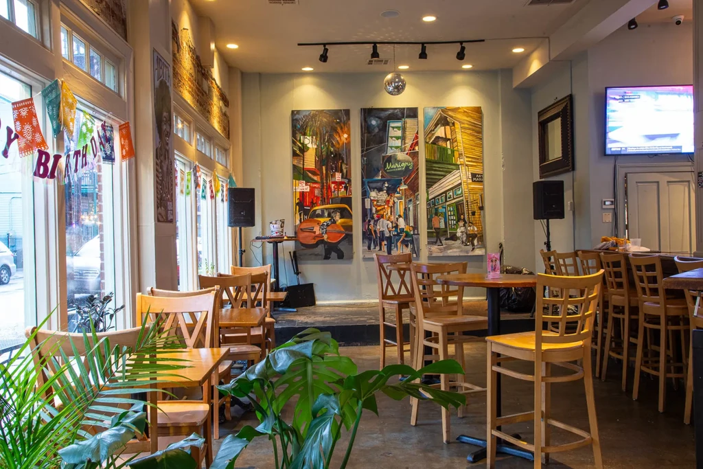 Vibrant restaurant interior with 'HAPPY BIRTHDAY' banner, colorful art, and bar.