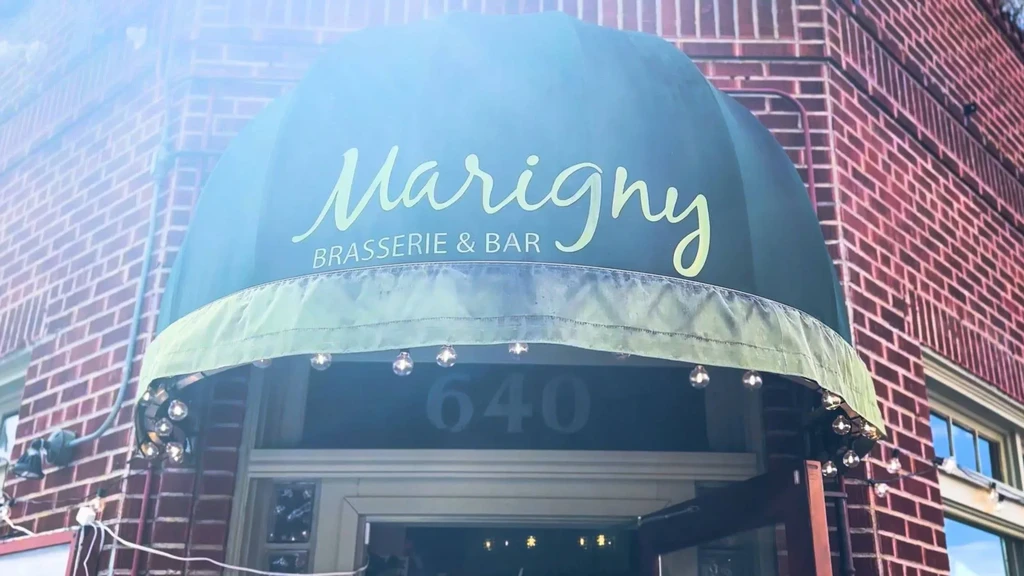 Marigny Brasserie & Bar, number 640, with lit green awning.