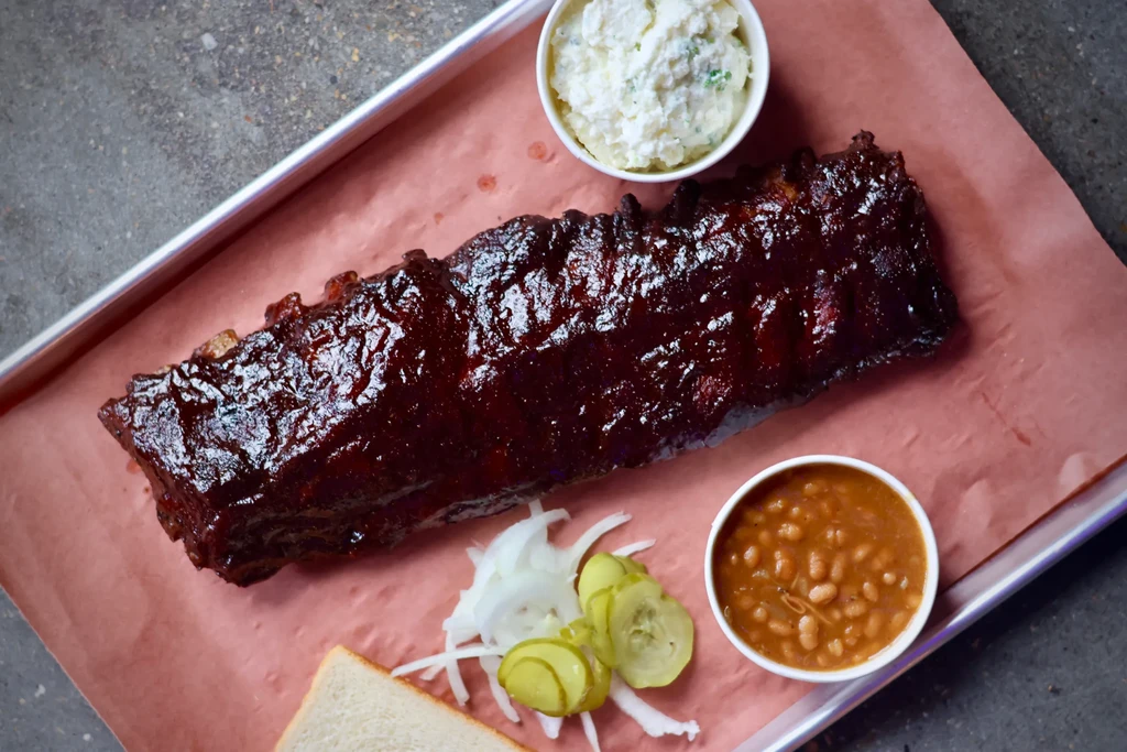 Full rack of sauced ribs, potato salad, baked beans, onions, pickles.