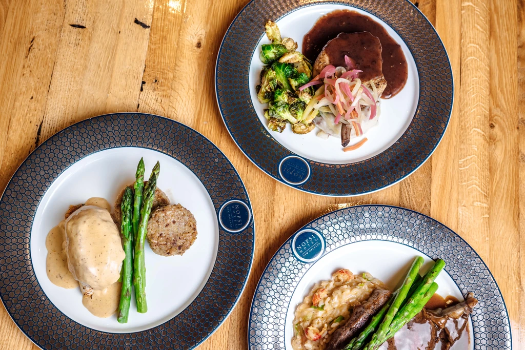 Three gourmet dishes on NOPSI HOTEL NEW ORLEANS dinnerware.