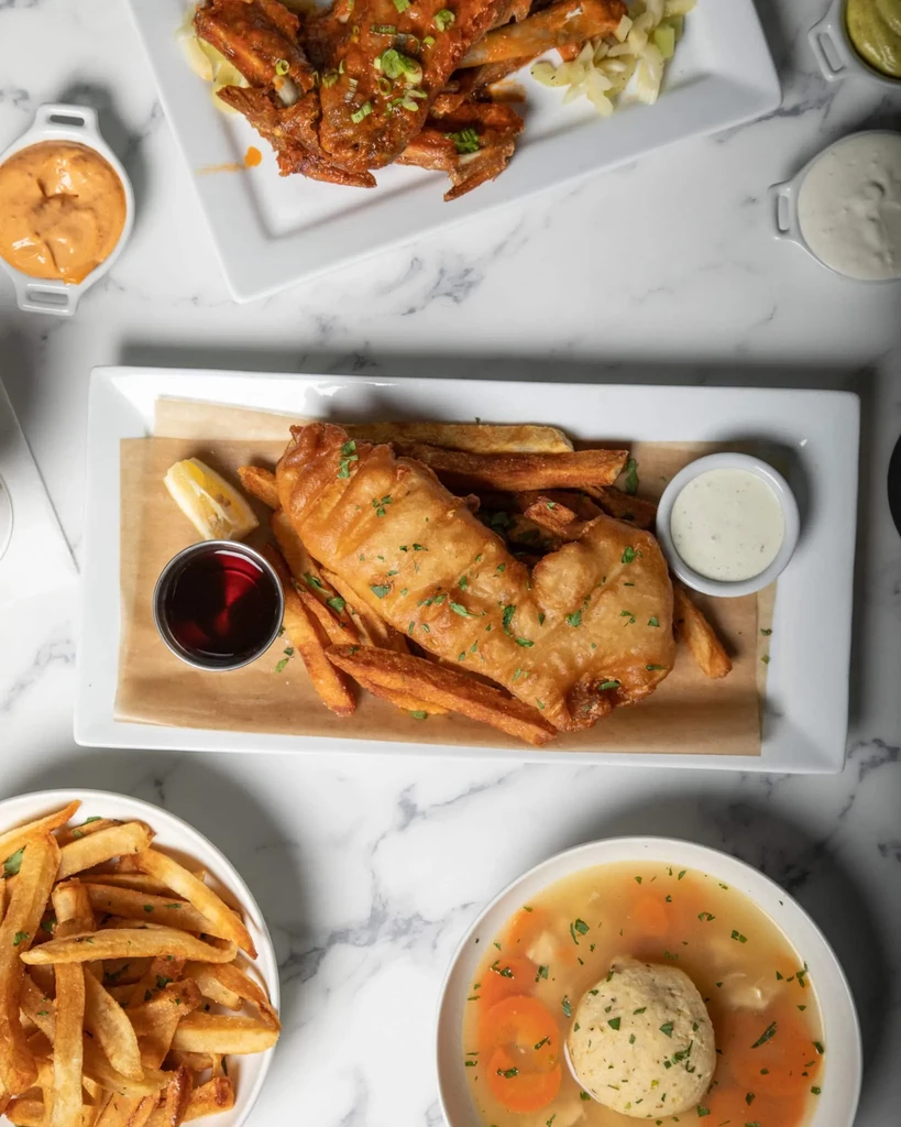 Overhead shot of fish, chips, wings, and matzo ball soup.