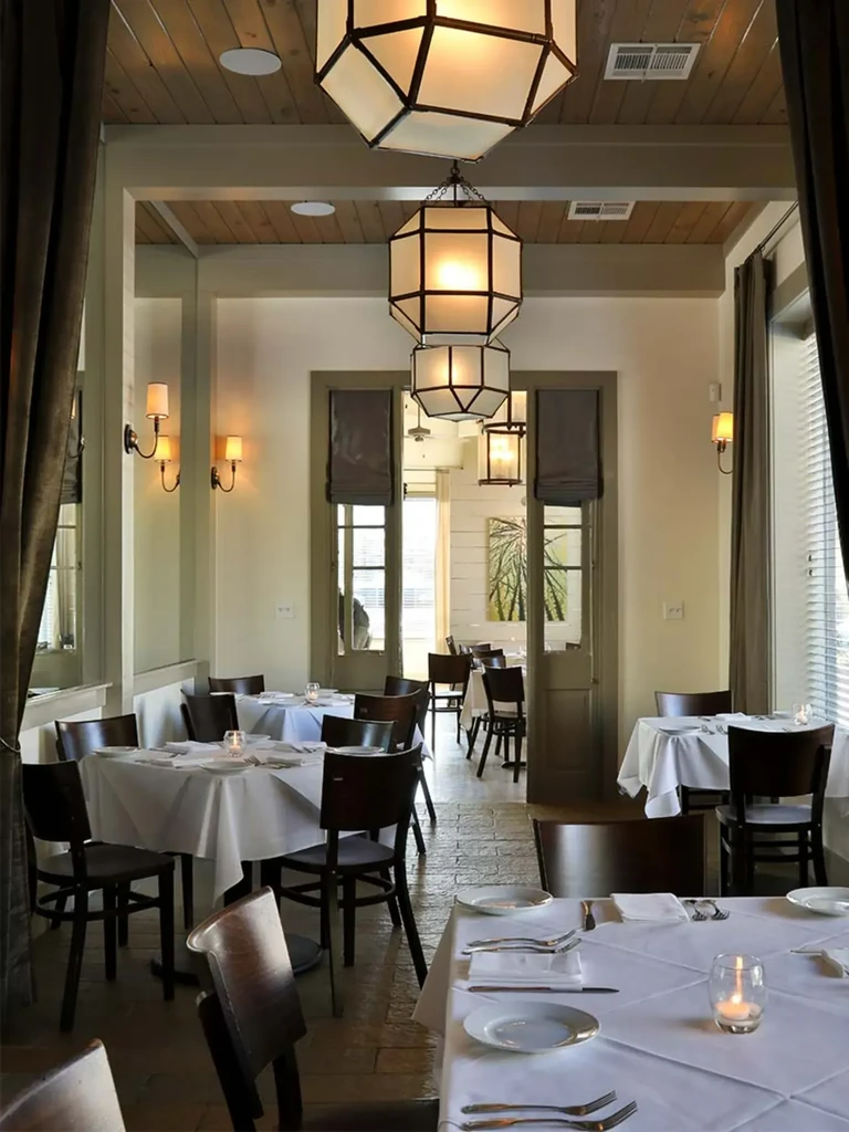 Elegant restaurant dining room with set tables and warm lighting.