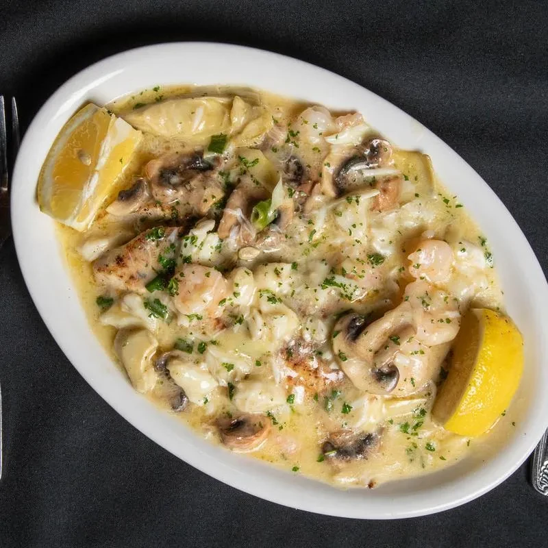 Creamy seafood, gnocchi, and mushroom dish with lemon and herbs.