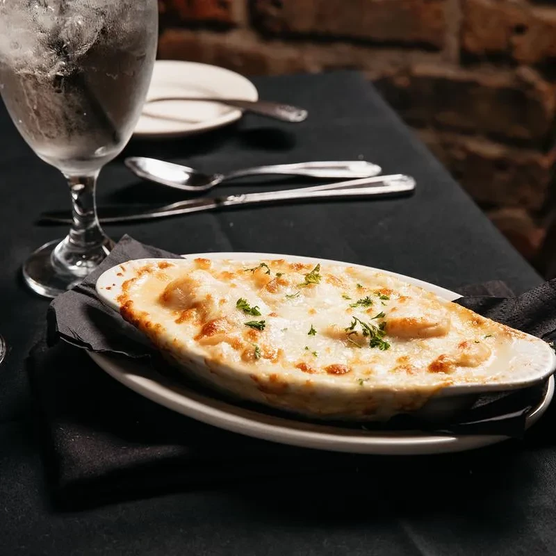 Hot oval gratin with melted cheese and fresh herbs.