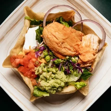 Vibrant chicken taco salad served in a crispy tortilla bowl.