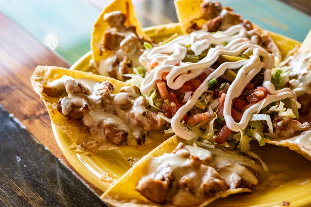 Nachos with chicken, cheese, lettuce, pico de gallo, and sour cream.