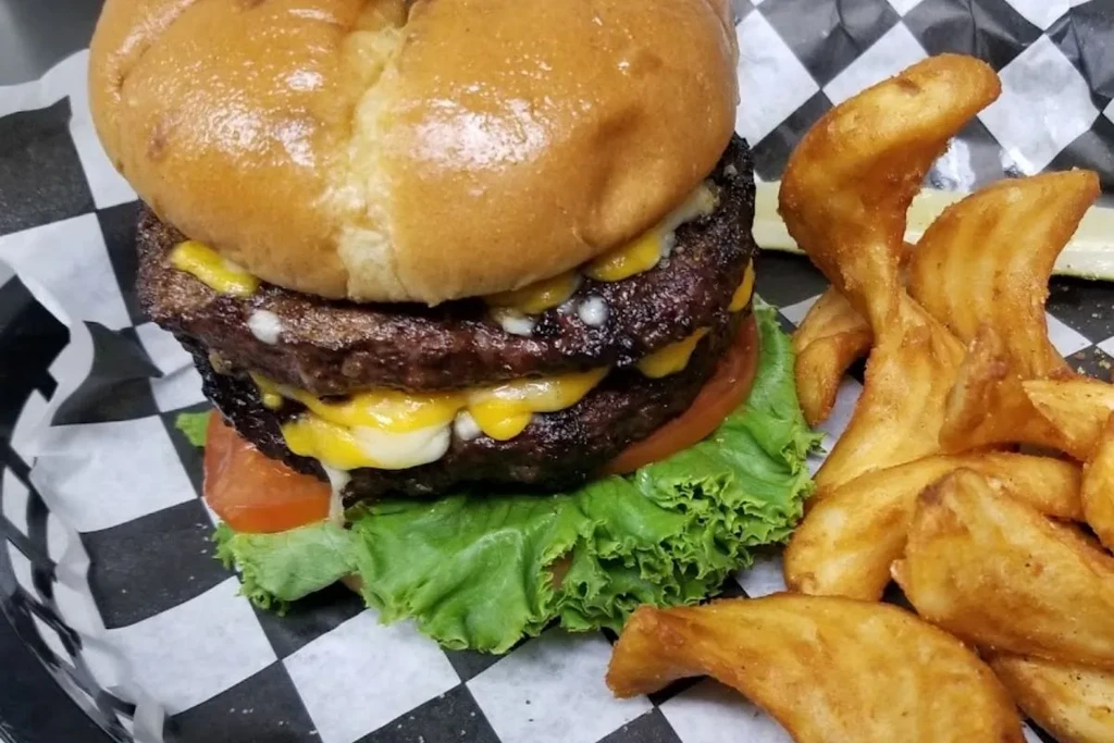 Double cheeseburger and wedge fries in a checkered basket.