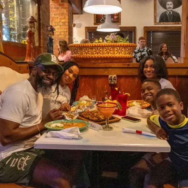 Smiling group of six people dining at a Mexican restaurant.