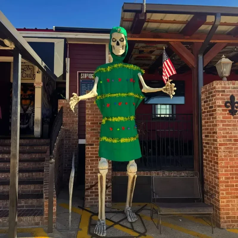 Large skeleton in green holiday costume holds an American flag.