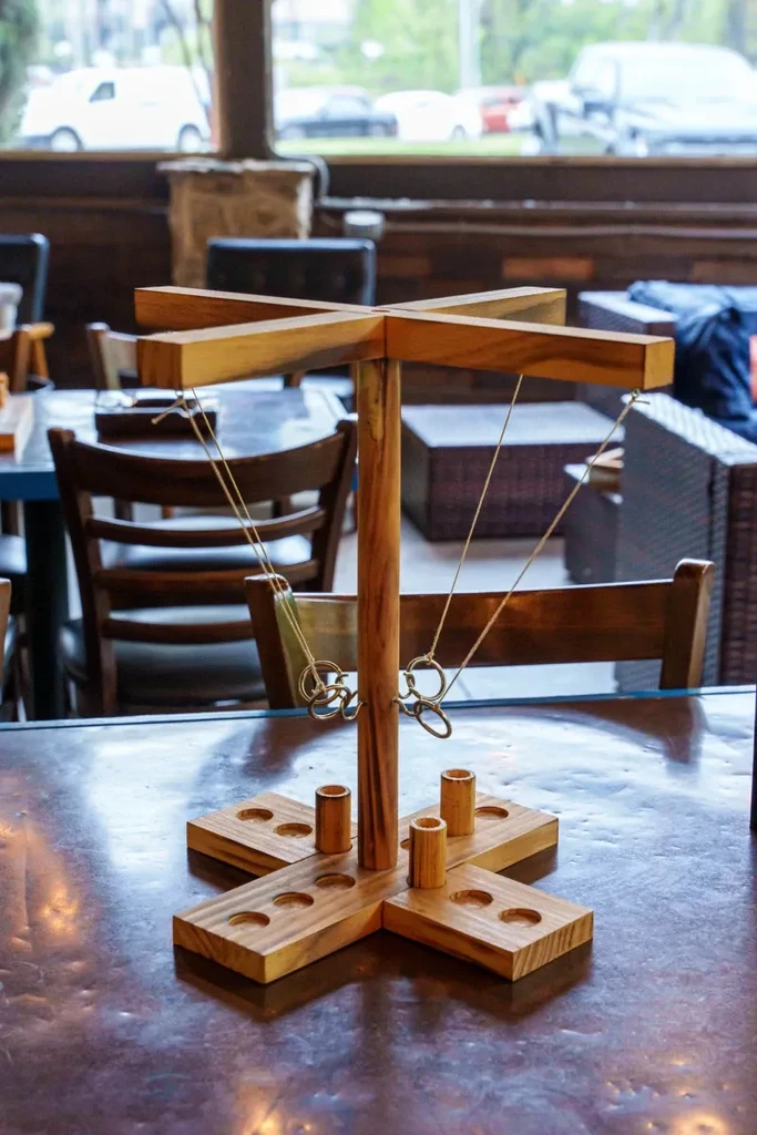 Wooden ring toss game on a tabletop in a restaurant.