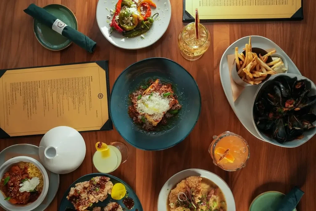 Overhead shot of a restaurant table laden with various dishes and drinks.