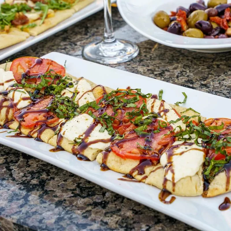 Caprese-style flatbread with mozzarella, tomatoes, basil, and balsamic glaze.