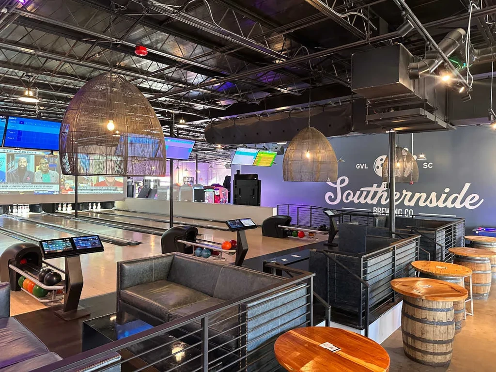 Modern bowling alley with Southernside Brewing Co. logo and barrel tables.