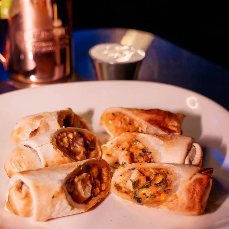 Six savory wraps cut in half, revealing filling, on a plate.