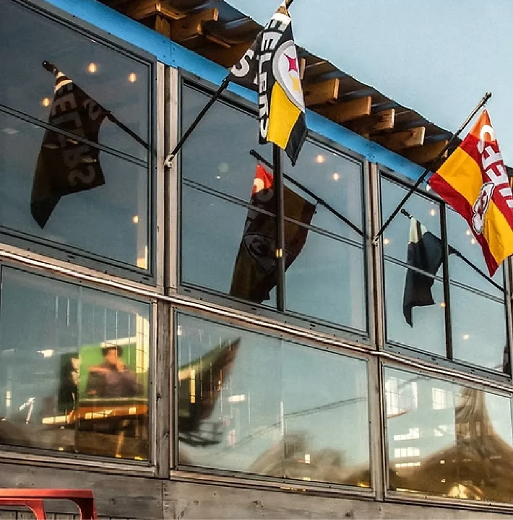 Building exterior with prominent Steelers flag above multi-paned windows.