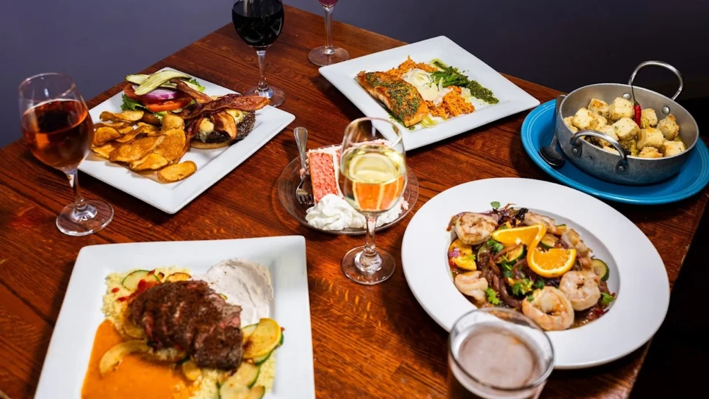 Restaurant table laden with a variety of colorful dishes and drinks.