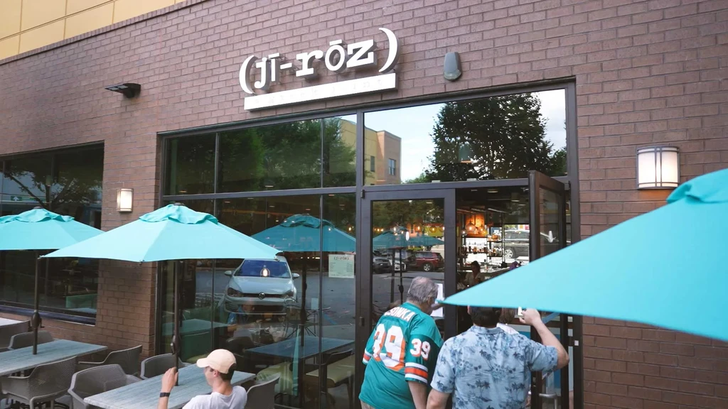 Restaurant "ji-rōz" exterior with outdoor patio, blue umbrellas, and people.
