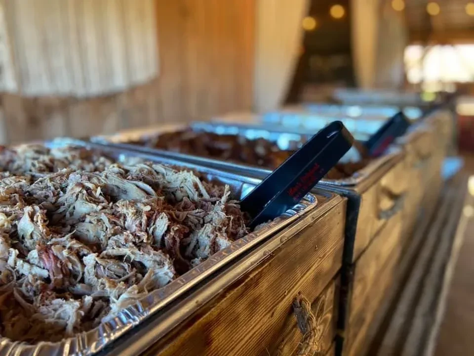 Buffet pan of moist shredded pulled pork with Kenny's tongs.