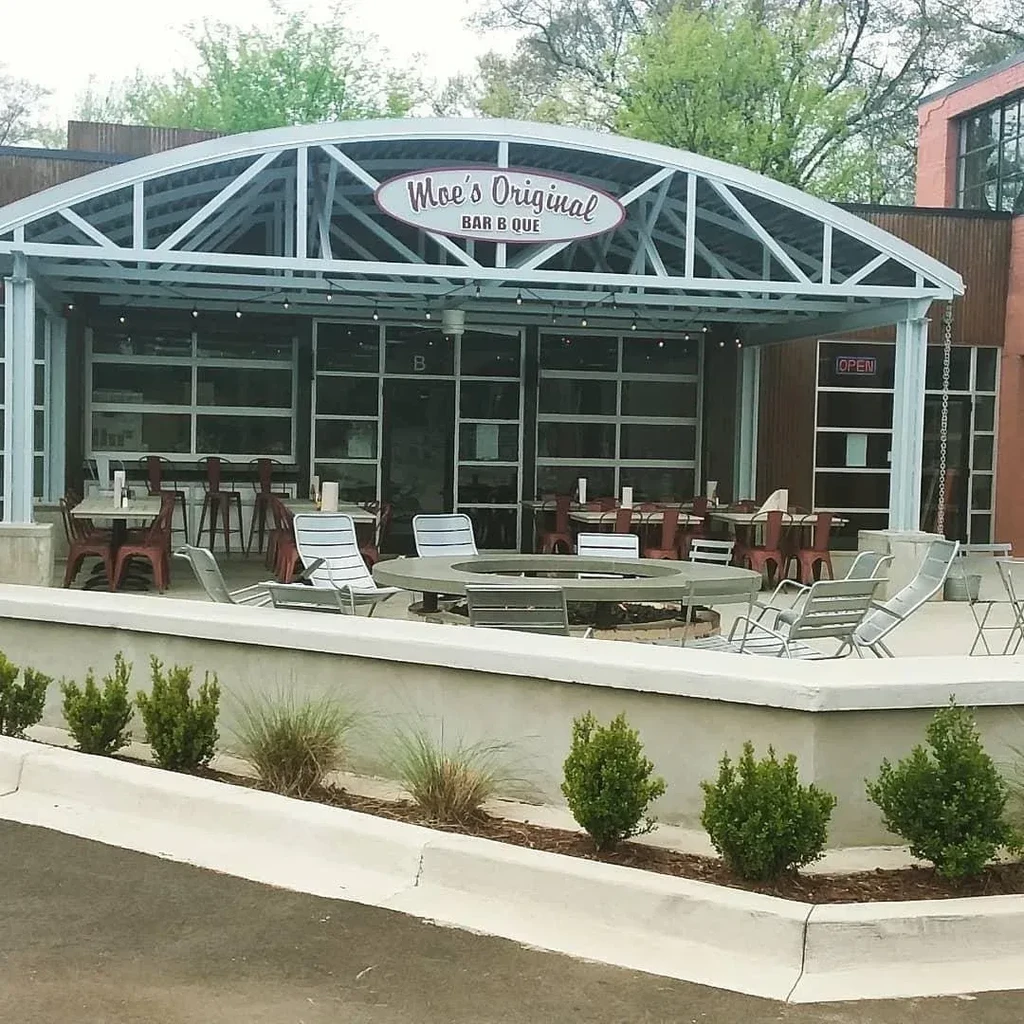 Moe's Bar B Que restaurant exterior, featuring an arched patio with seating.