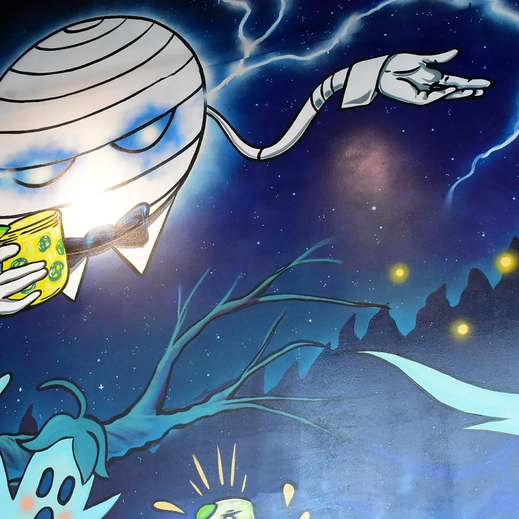 Mural of a cartoon mummy holding a mug under a starry sky.