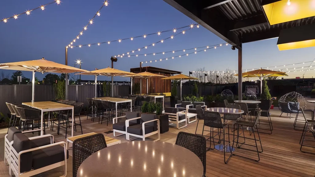 Inviting restaurant patio at dusk with string lights and varied seating.
