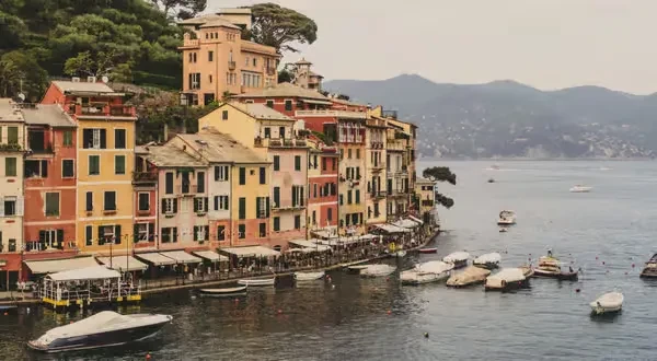Colorful hillside coastal town with waterfront dining and harbor boats.