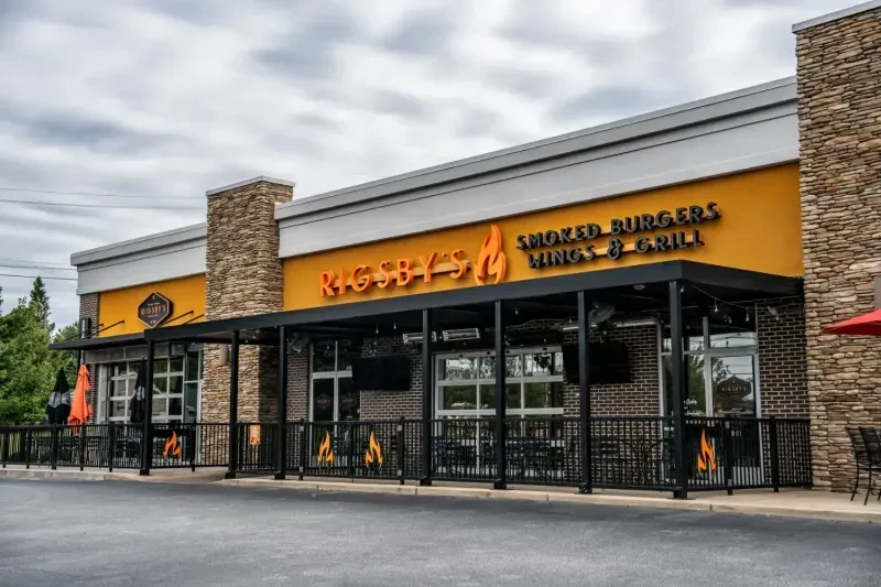 Rigsby's restaurant exterior with orange facade, stone pillars, and covered patio.