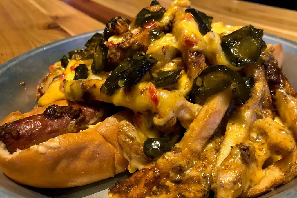 Loaded hot dog with cheese sauce, fries, and jalapeños.