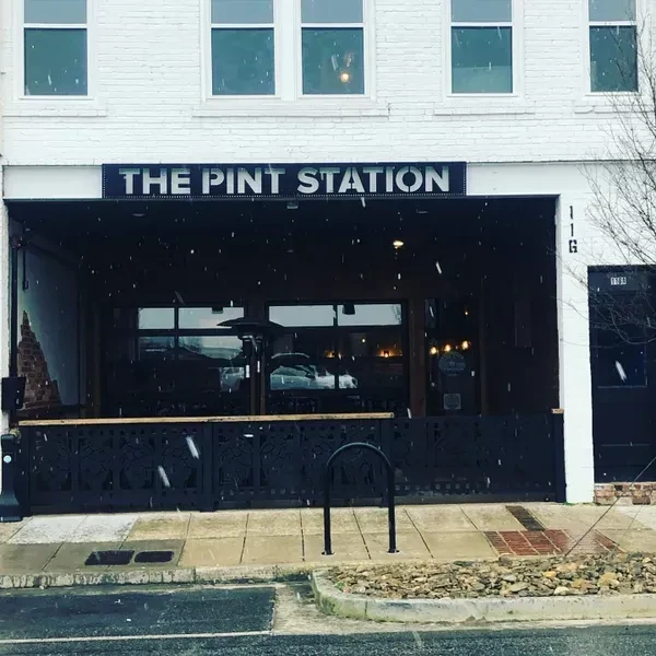The Pint Station bar exterior with patio, bicycle rack, and light snow.