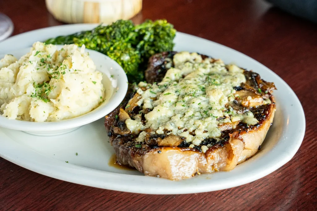 Steak with mushrooms, blue cheese, mashed potatoes, and broccoli.