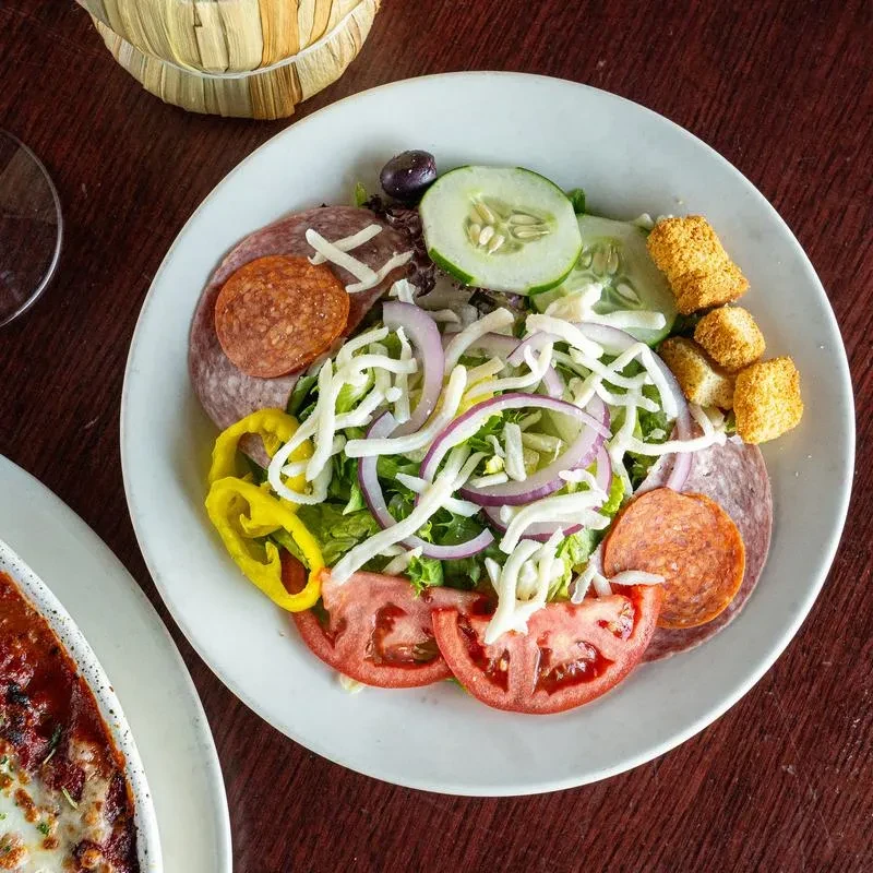 Overhead view of a colorful Italian salad with pepperoni and salami.