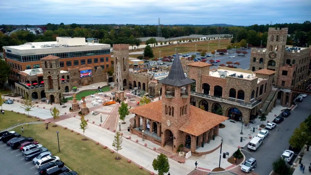 Aerial view of castle-style commercial complex, central plaza, and modern building.