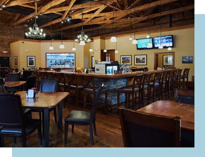Spacious restaurant interior with a U-shaped bar and wooden decor.