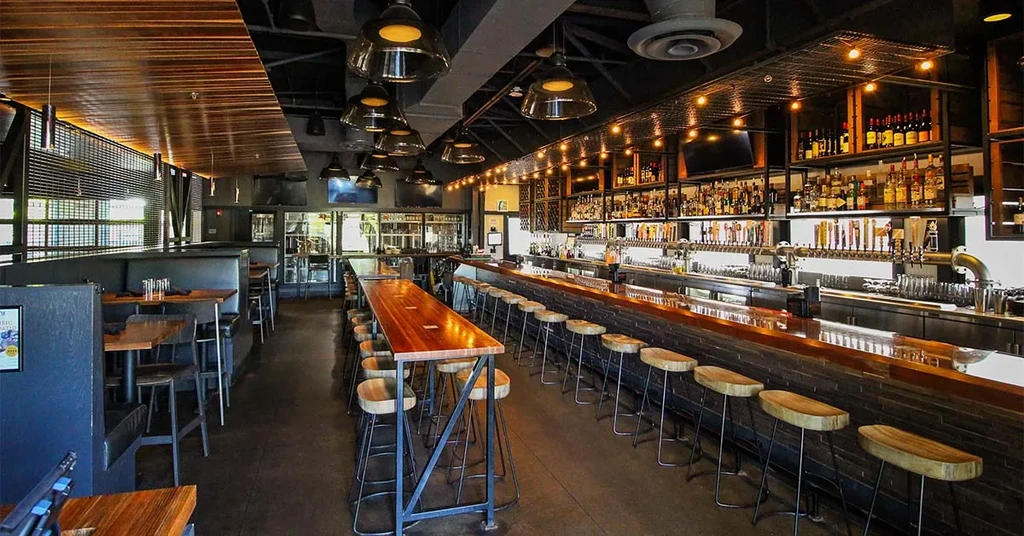 Modern industrial-chic bar and restaurant interior with dining area.