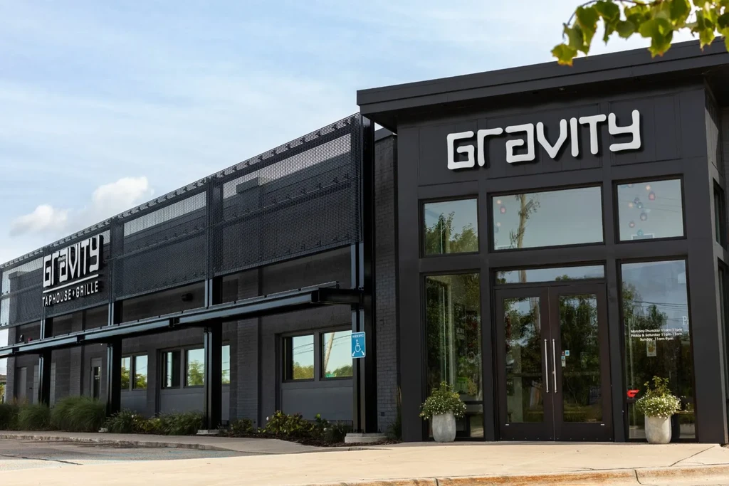 GRAVITY Taphouse + Grille: sleek, dark industrial exterior with glass windows.