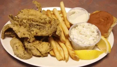 Fried soft-shell crab platter with fries, coleslaw, lemon, and dipping sauce.