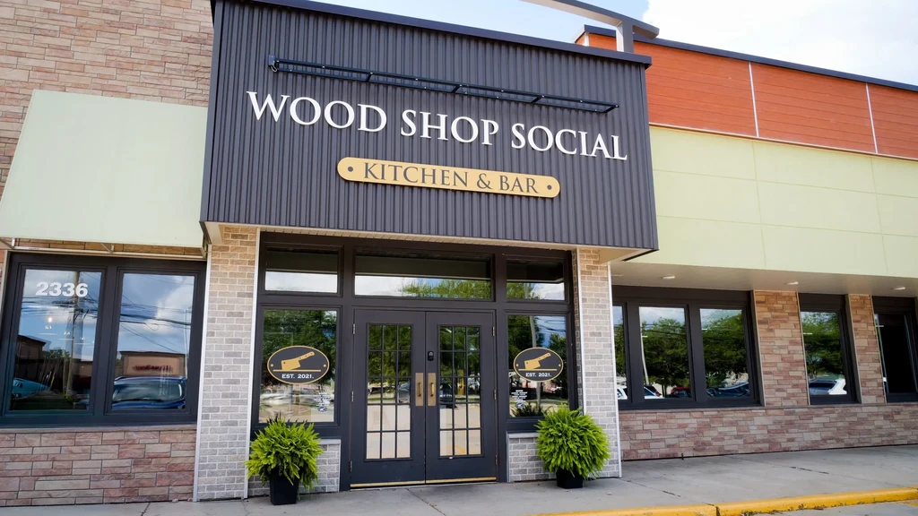 Facade of modern Wood Shop Social Kitchen & Bar with brick and metal.