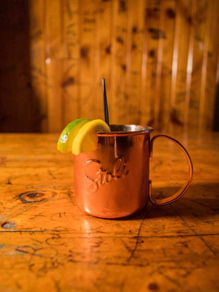 Stoli copper Moscow Mule with lime, lemon, and straw.