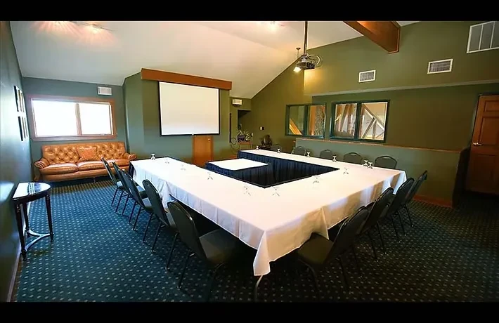 Professional meeting room with large U-shaped table prepared for an event.