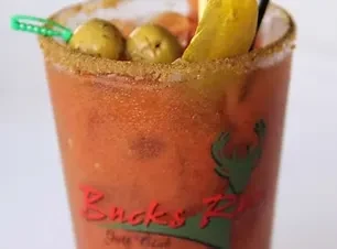 Bloody Mary with olives, pickle, spiced rim, and "Bucks Run" logo.