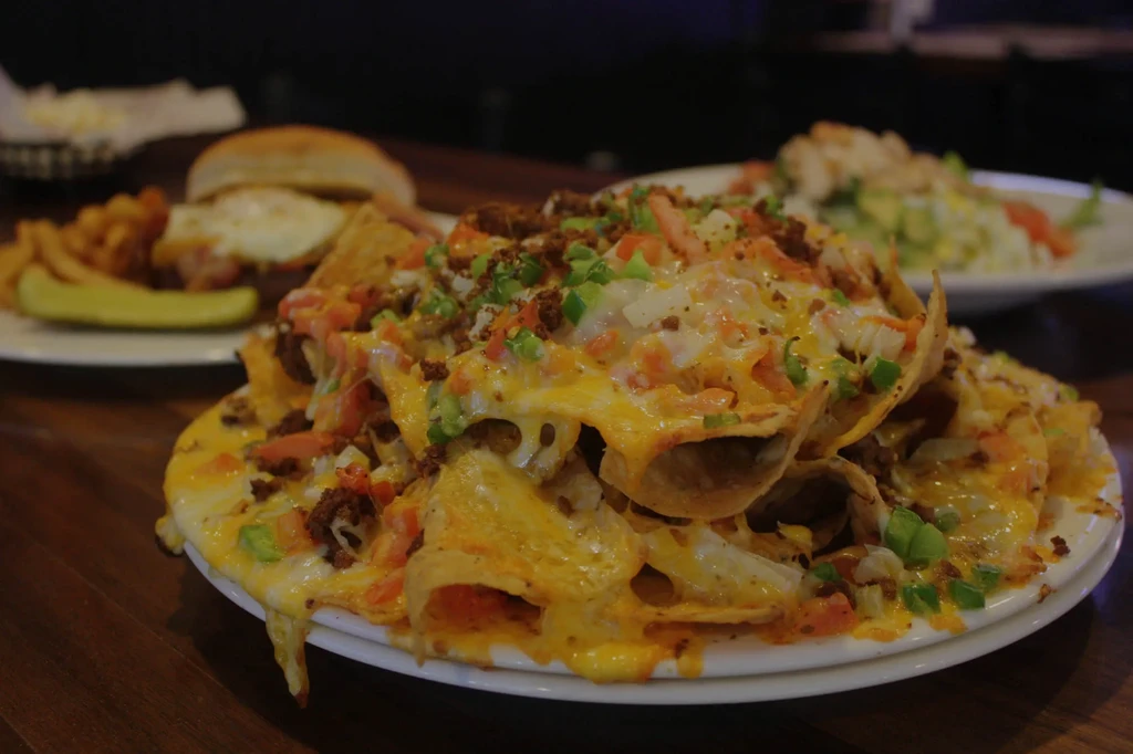 Loaded nachos piled high with melted cheese, ground meat, and vegetables.