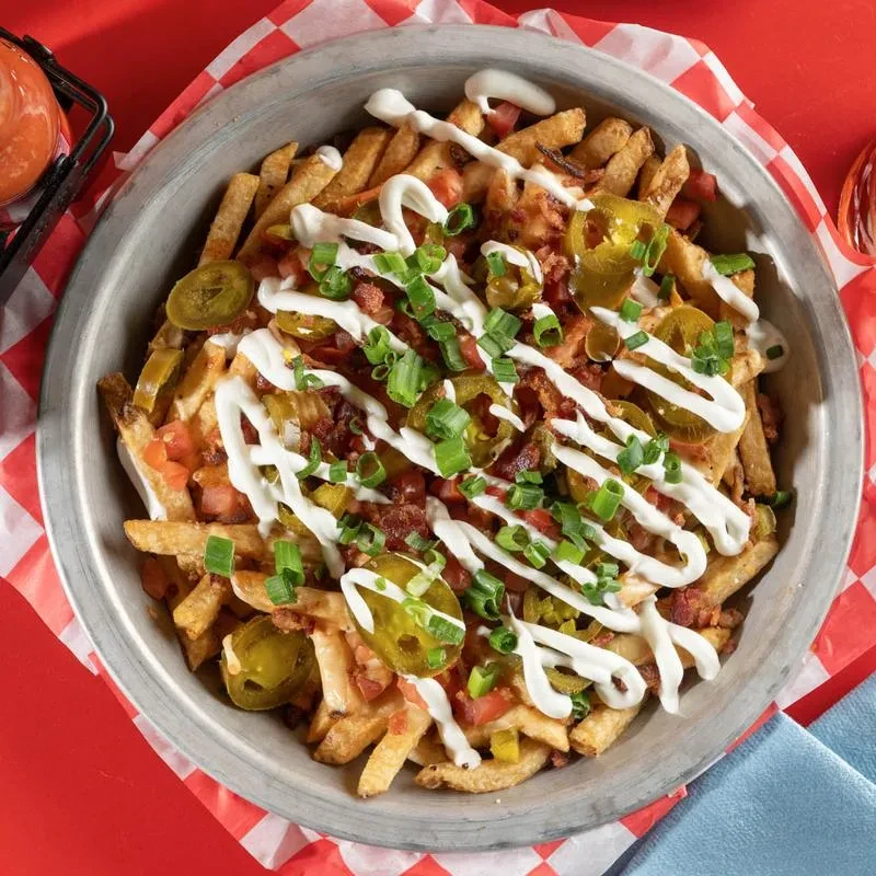Loaded french fries with melted cheese, jalapeños, bacon, sour cream, green onions.