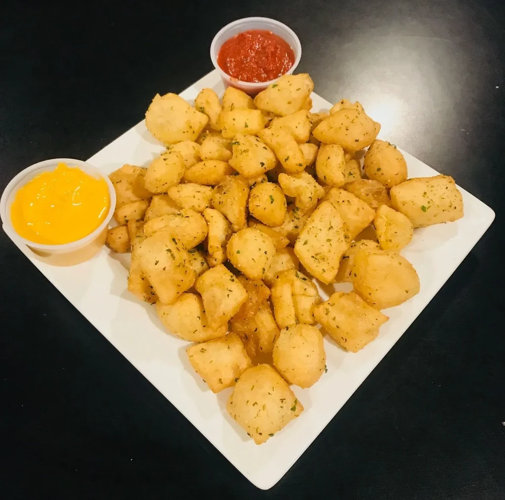 Plate of herbed fried dough with cheese and marinara dipping sauces.