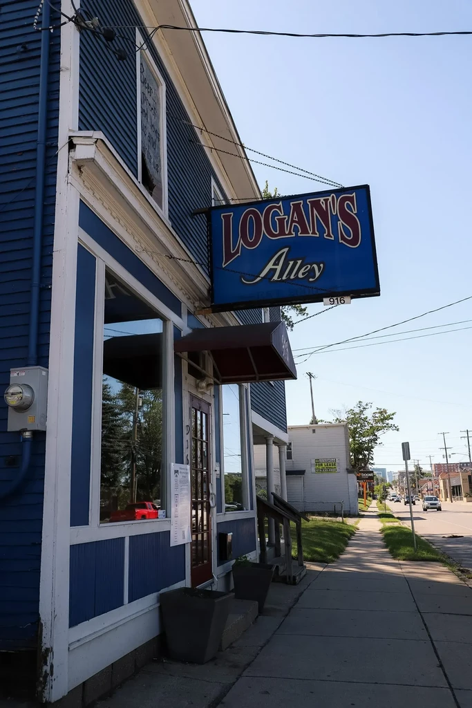 Exterior of blue 'LOGAN'S Alley 916' building with a red awning.