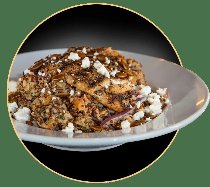 Grilled chicken breast on quinoa salad with feta and pepitas.