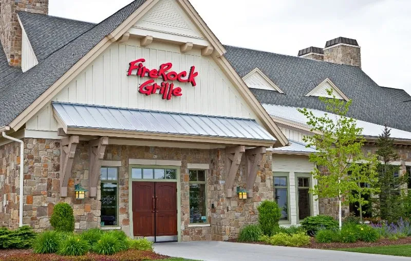 FireRock Grille's rustic stone and siding exterior with prominent red sign.