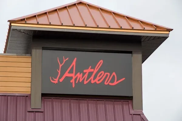 Antlers sign on a modern building with metal roof.